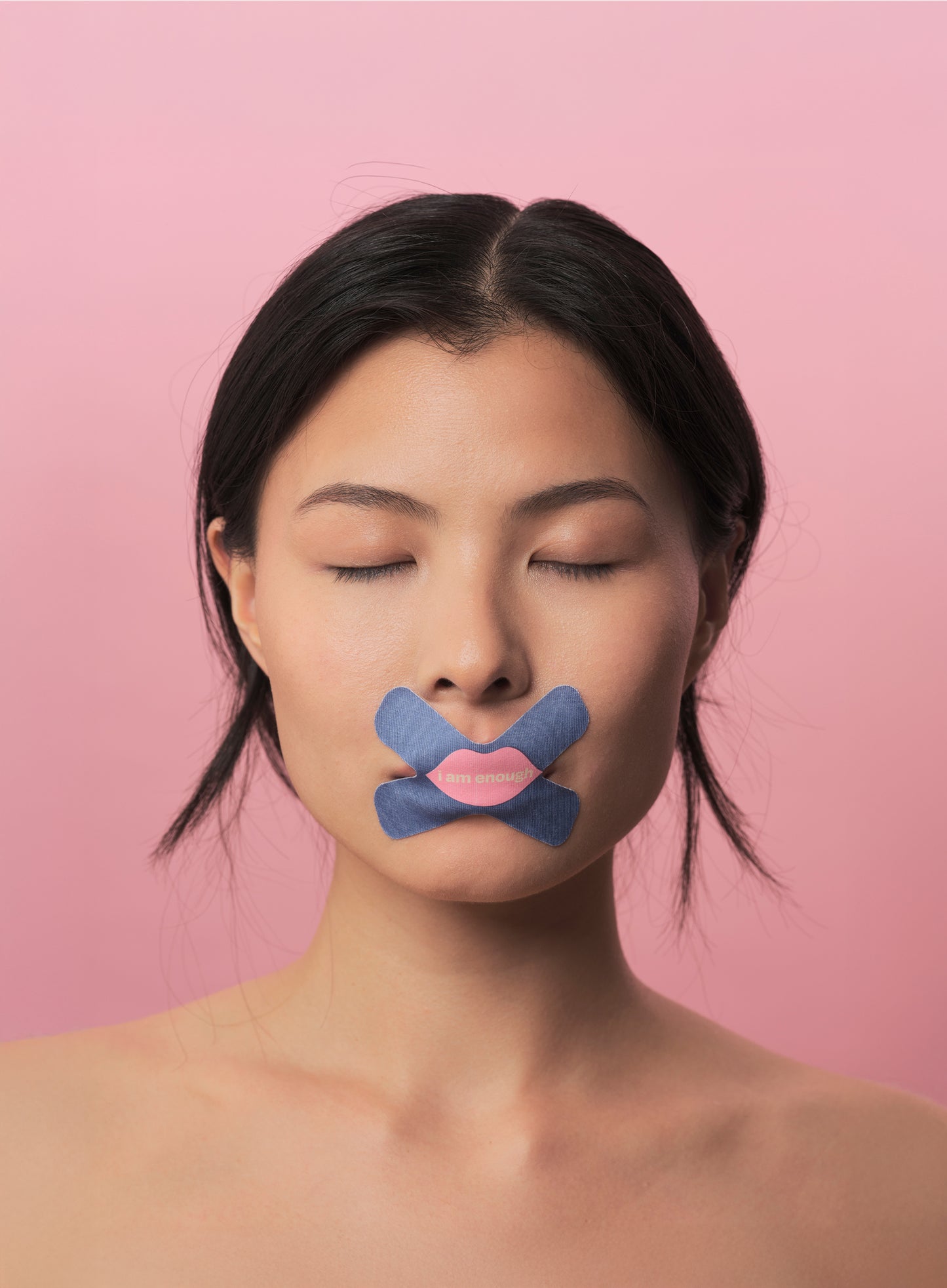 Woman with a cross mouth tape and pink lips on a pink background
