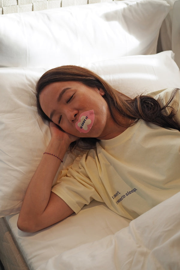 We Shut It lip mouth tape for better sleep worn by a model sleeping in bed. 